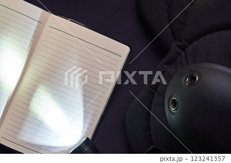 紺色の制服の上のフラッシュライトと手帳 123241357