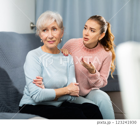 Adult daughter asking for forgiveness from upset elderly mother on sofa Adult daughter asking for forgiveness from upset elderly mother on sofa 123241930
