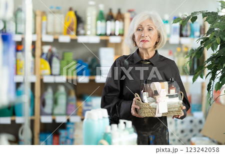 Elderly woman chooses gift set of shampoo, liquid soap and cosmetic items in supermarket Elderly woman chooses gift set of shampoo, liquid soap and cosmetic items in supermarket 123242058