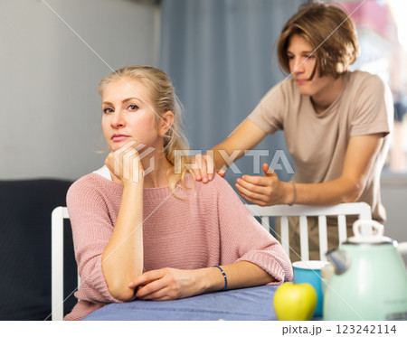 Teenager trying to apologize to offended mother at home Teenager trying to apologize to offended mother at home 123242114