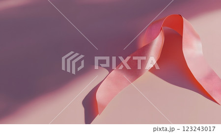 Elegant pink ribbon on a minimalist backdrop symbolizing the fight against breast cancer during Awareness Month. Awareness concept 123243017