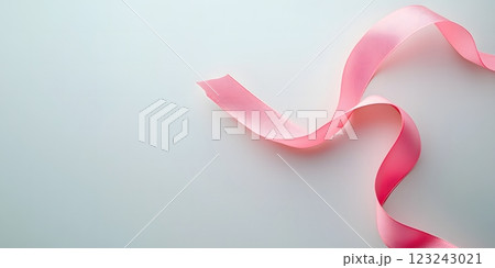 Elegant pink ribbon softly curled on a light backdrop highlighting the essence of breast cancer awareness. Awareness concept Elegant pink ribbon softly curled on a light backdrop highlighting the essence of breast cancer awareness. Awareness concept 123243021