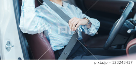 Business woman driver hand fastening seat belt during sitting inside a car and driving in the road. safety, trip, journey and transport concept Business woman driver hand fastening seat belt during sitting inside a car and driving in the road. safety, trip, journey and transport concept 123243417