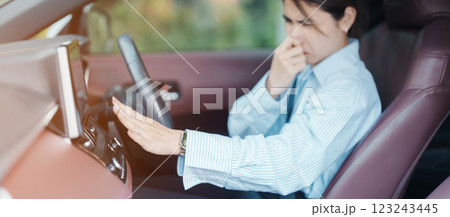 Asian woman hold nose because bad smell after turn on air conditioning in car. Woman driving car with broken air conditioning in hot summer weather. Businesswoman driver is tired, overheat and stress Asian woman hold nose because bad smell after turn on air conditioning in car. Woman driving car with broken air conditioning in hot summer weather. Businesswoman driver is tired, overheat and stress 123243445