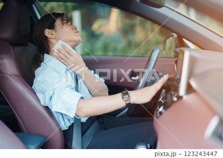 woman driving car with broken air conditioner in hot summer weather, uses tissue paper napkin to wipe the sweat off her forehead. Businesswoman driver is tired, Exhausted overheated and stressed woman driving car with broken air conditioner in hot summer weather, uses tissue paper napkin to wipe the sweat off her forehead. Businesswoman driver is tired, Exhausted overheated and stressed 123243447