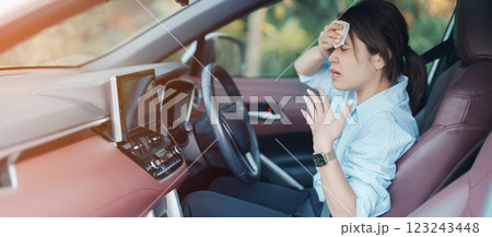woman driving car with broken air conditioner in hot summer weather, uses tissue paper napkin to wipe the sweat off her forehead. Businesswoman driver is tired, Exhausted overheated and stressed woman driving car with broken air conditioner in hot summer weather, uses tissue paper napkin to wipe the sweat off her forehead. Businesswoman driver is tired, Exhausted overheated and stressed 123243448