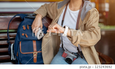Close up shot of Asian woman looking at her wristwatch waiting for the arrival of train. Close up shot of Asian woman looking at her wristwatch waiting for the arrival of train. 123243692