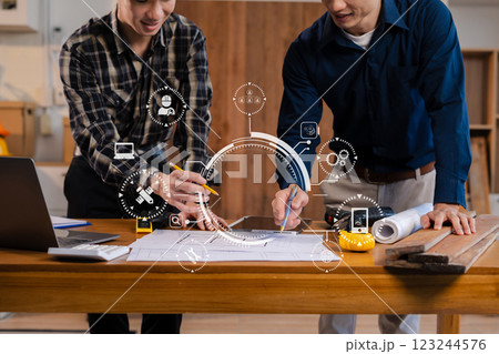 team discussing data working and tablet, laptop with on architectural project at construction site at desk in office. team discussing data working and tablet, laptop with on architectural project at construction site at desk in office. 123244576