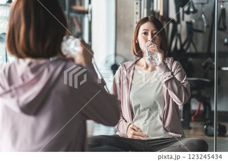 妊娠中にジムで運動・ストレッチ・マタニティトレーニングするプレママ・妊婦の女性 123245434