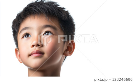 Focused young boy looking upwards, his gaze filled with curiosity and a hint of daydreaming. Represents innocence and wonder. Focused young boy looking upwards, his gaze filled with curiosity and a hint of daydreaming. Represents innocence and wonder. 123246696