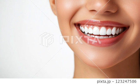 A close-up of a woman's radiant smile showcasing healthy, aligned white teeth and pink lips against a clean background. Smile perfectly. 123247586