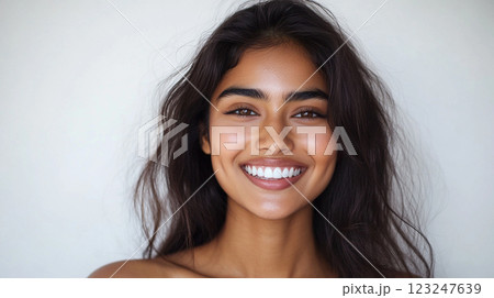 Radiant woman with beautiful smile, shiny dark hair. A portrait of warmth & charm against a plain backdrop; capturing her natural elegance. 123247639