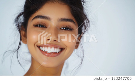 Radiant beauty: A close-up showcasing a woman's warm smile, her flawless skin, and perfectly styled hair against a soft, neutral backdrop. 123247700