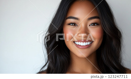 Radiant smile. Portrait of a young woman with beautiful skin, dark hair and bright white teeth. Beauty and wellness close up studio shot. 123247711