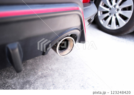 Close up of car exhaust pipe , Exhaust pipe under the rear bumper of a car Close up of car exhaust pipe , Exhaust pipe under the rear bumper of a car 123248420