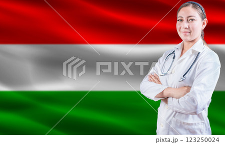 Female Doctor On Hungarian Flag. Doctor With Crossed Arms On Hungarian Flag. Hungary Health And Care Concept Female Doctor On Hungarian Flag. Doctor With Crossed Arms On Hungarian Flag. Hungary Health And Care Concept 123250024