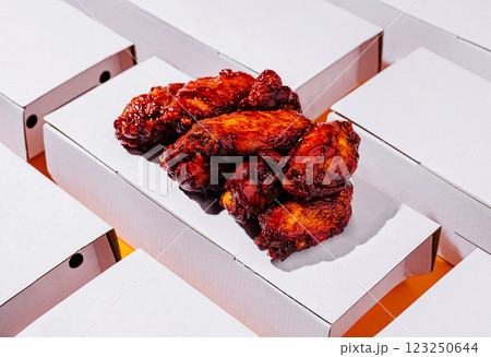 Crispy chicken wings served on a white takeout container 123250644