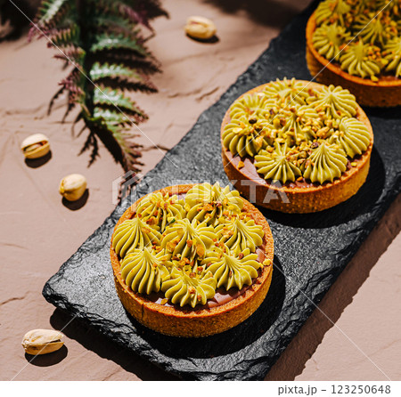 Delicious pistachio tart displayed on a slate serving board Delicious pistachio tart displayed on a slate serving board 123250648