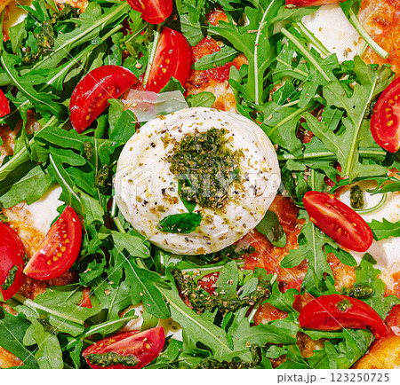 Freshly made pizza topped with arugula and cherry tomatoes 123250725