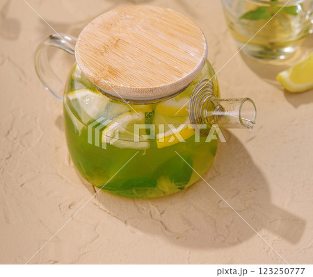 Fresh mint tea in glass teapot with lemon slices Fresh mint tea in glass teapot with lemon slices 123250777