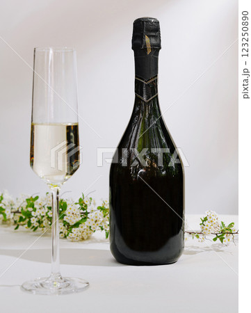 Sparkling wine and glass with floral decoration on a table Sparkling wine and glass with floral decoration on a table 123250890
