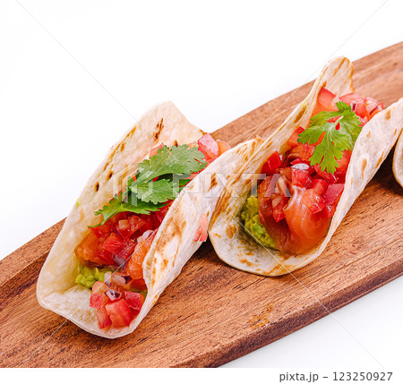 Delicious tacos with fresh ingredients served on wooden board 123250927