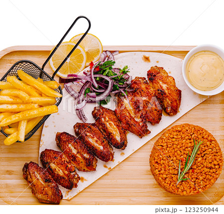 Spicy grilled chicken wings served with fries and rice Spicy grilled chicken wings served with fries and rice 123250944