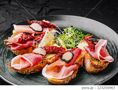 Delicious gourmet crostini topped with cured meats and cheese 123250963