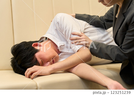 アルコール中毒で倒れる男性と介抱する女性 アルコール中毒で倒れる男性と介抱する女性 123251239