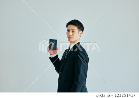 パスポートを持つ20代の若い男性 パスポートを持つ20代の若い男性 123251417
