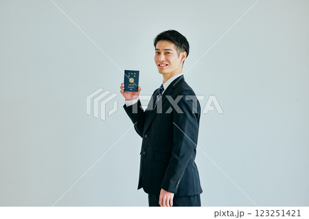 パスポートを持つ20代の若い男性 パスポートを持つ20代の若い男性 123251421