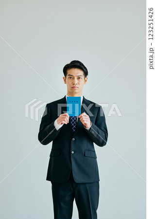 年金手帳を持つ20代の若い男性 年金手帳を持つ20代の若い男性 123251426