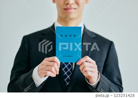 年金手帳を持つ20代の若い男性 123251428