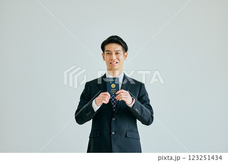 パスポートを持つ20代の若い男性 パスポートを持つ20代の若い男性 123251434