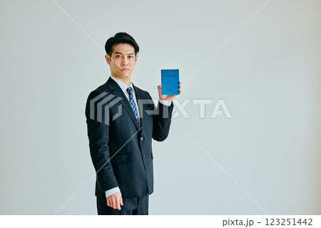 年金手帳を持つ20代の若い男性 123251442