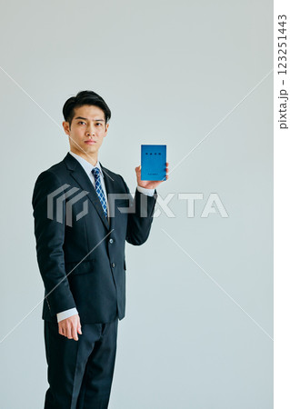 年金手帳を持つ20代の若い男性 年金手帳を持つ20代の若い男性 123251443