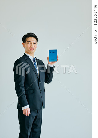 年金手帳を持つ20代の若い男性 年金手帳を持つ20代の若い男性 123251446