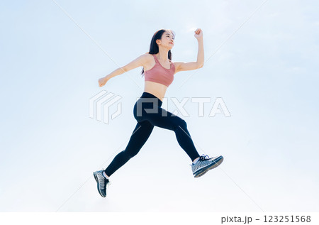 スポーツウェアでジャンプする若い女性 スポーツウェアでジャンプする若い女性 123251568