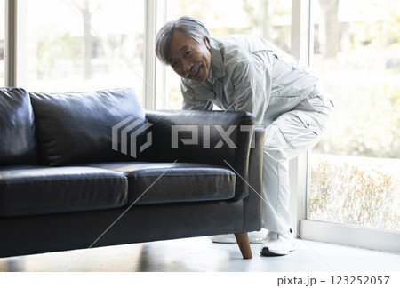 家具を運ぶ作業服のシニア男性 123252057