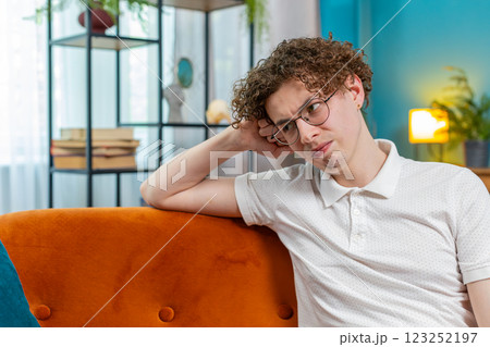 Thoughtful man sitting at home looks pensive thinks of unrequited love depressed bad feeling burnout Thoughtful man sitting at home looks pensive thinks of unrequited love depressed bad feeling burnout 123252197