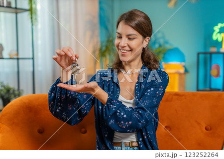 Happy woman real estate agent lifting hand showing the keys of new home buying or renting property 123252264