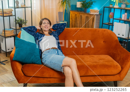 Tired young woman in casuals sitting on comfortable home couch, taking a rest, daytime nap relaxing 123252265