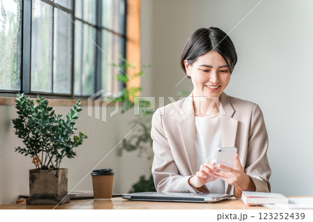 カフェでスマホを使う若いアジア人ビジネスウーマン 123252439
