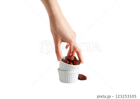 Dried dates in white bowls and hand, isolated on white background, PNG 123253105