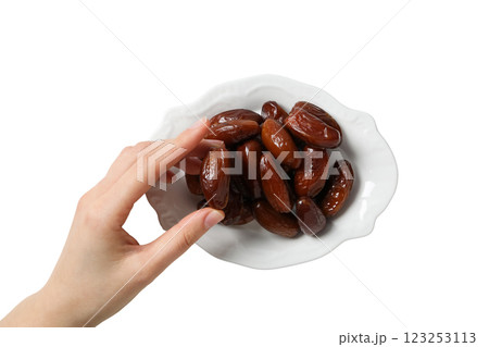 Dried dates on a white saucer and hand, close up, top view, isolated on white background, PNG 123253113