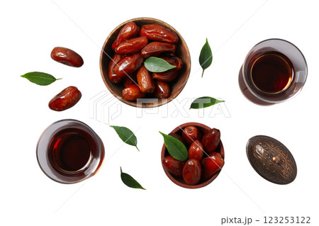 Dried dates in wooden bowls, tea in Armudu glasses and a small bronze bowl with a lid, top view, isolated on white background, PNG Dried dates in wooden bowls, tea in Armudu glasses and a small bronze bowl with a lid, top view, isolated on white background, PNG 123253122