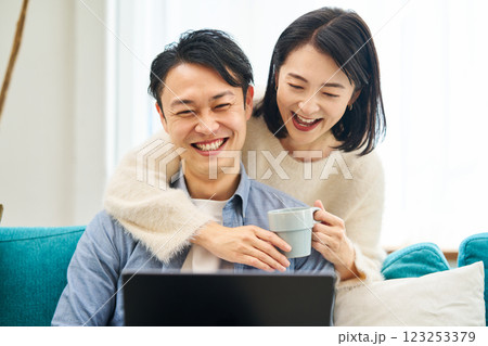 パソコンのモニターを見ながら笑談する夫婦 パソコンのモニターを見ながら笑談する夫婦 123253379