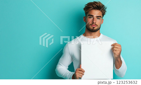Stylish man in white shirt holding a blank sign on a blue background, perfect for your message or design. Add your text and stand out. Stylish man in white shirt holding a blank sign on a blue background, perfect for your message or design. Add your text and stand out. 123253632