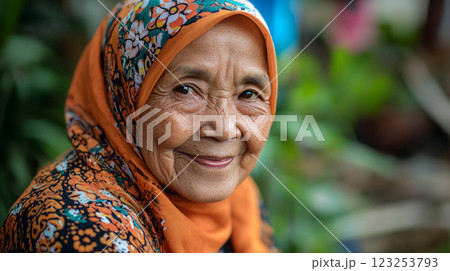Elderly woman with floral patterned headscarf smiles softly, exuding warmth and grace. Wrinkles tell stories of a life well-lived. 123253793