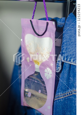 Purple hanging moisture absorber bag collecting humidity in a closet space. High quality photo 123254213